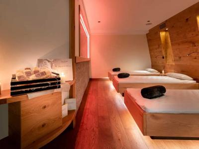 Camera spa con letti, candele accese e atmosfera rilassante.