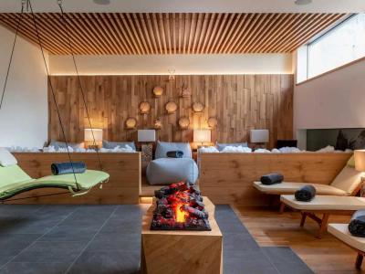 Relaxation room with loungers, fireplace, and wooden decorations.