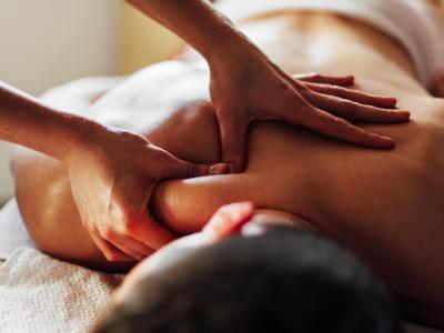 Relaxing back massage with oil, hands pressing on the shoulders.