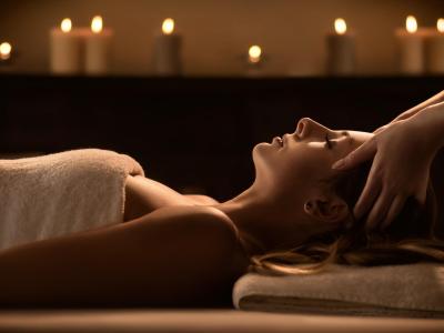 Woman receiving a relaxing massage with lit candles.