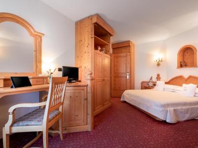 Cozy room with wooden furniture, double bed, and desk with mirror.