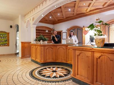 Hotel reception with wooden decor and welcoming staff.