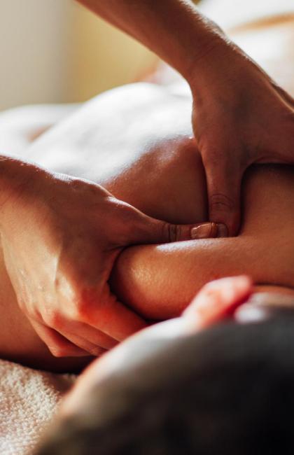 Relaxing back massage with oil, hands pressing on the shoulders.