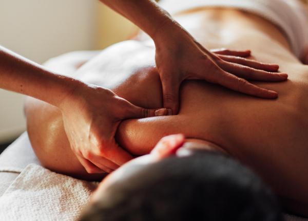 Relaxing back massage with oil, hands pressing on the shoulders.