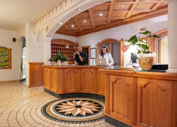 Hotel reception with wooden decor and welcoming staff.