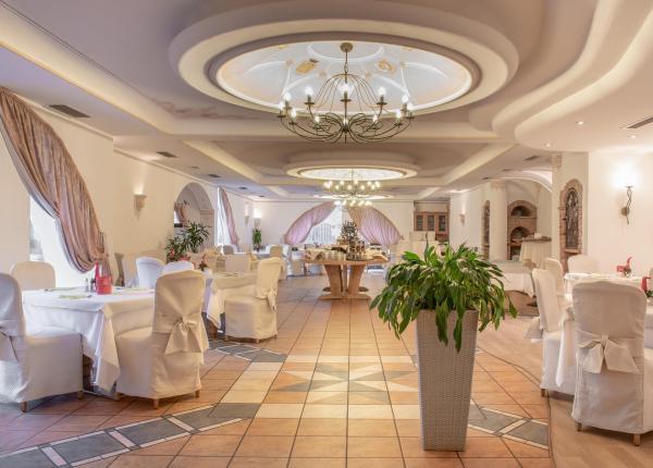 Elegantes Restaurant mit raffinierter Dekoration, Kronleuchtern und gedeckten Tischen.