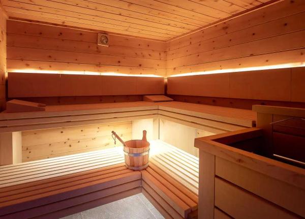 A wooden sauna with bucket and ladle.