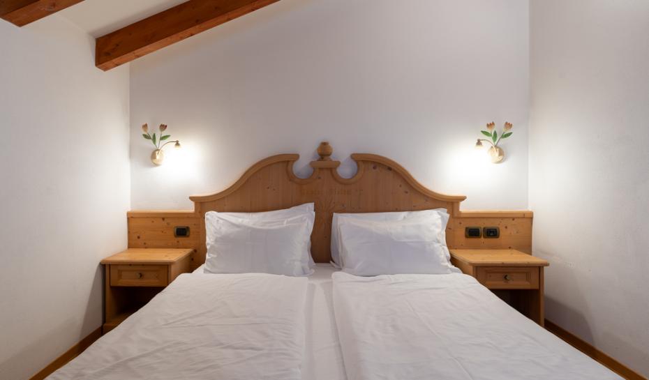 Cozy room with double bed and soft wooden lighting.